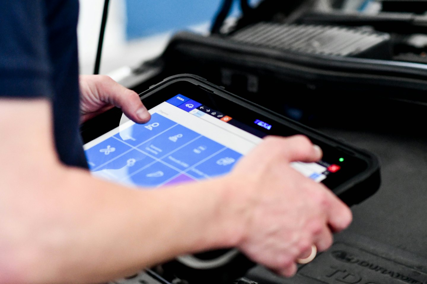 Un technicien utilise une tablette pour diagnostiquer un moteur.